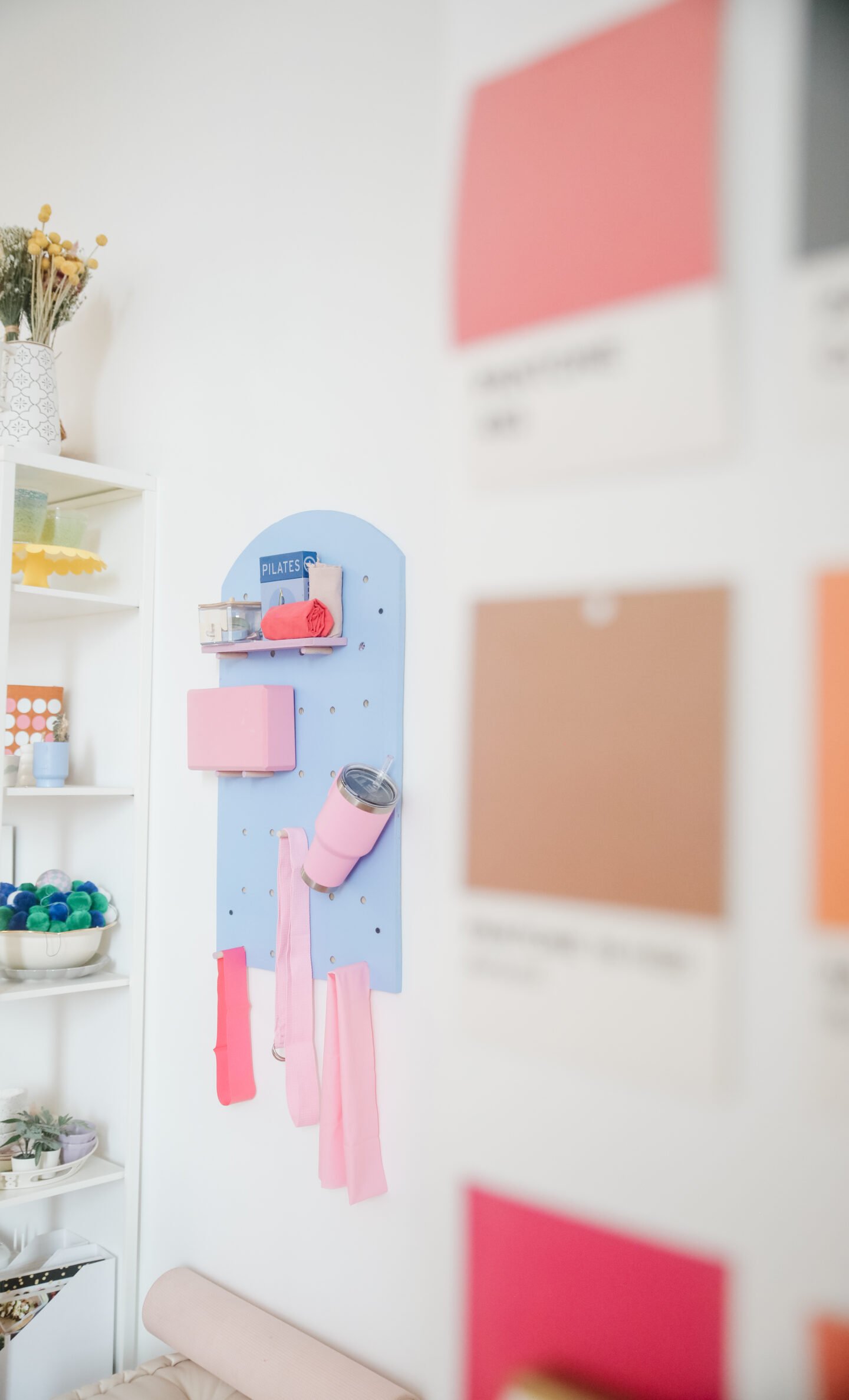 a pantone wall with a colourful pilates organizer hanged in the wall