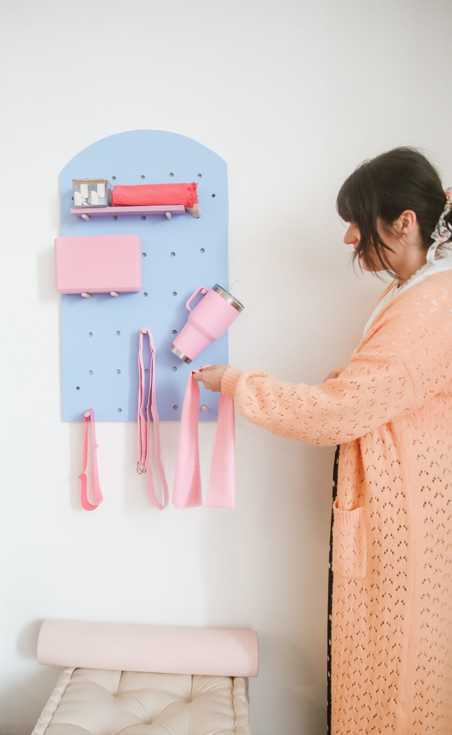 a colourful pilates organizer filled with accessories hanged in the wall