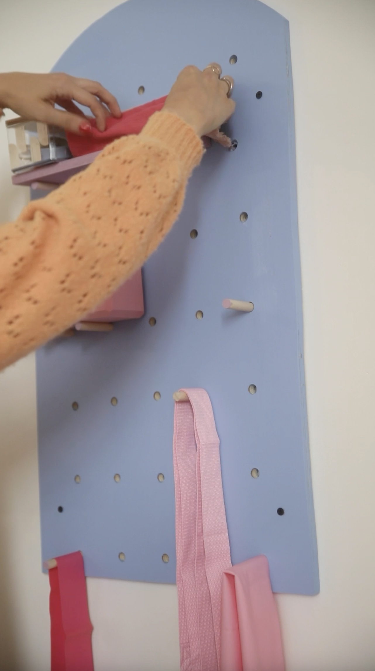 Organizing pilates accessories on pegboard on the wall