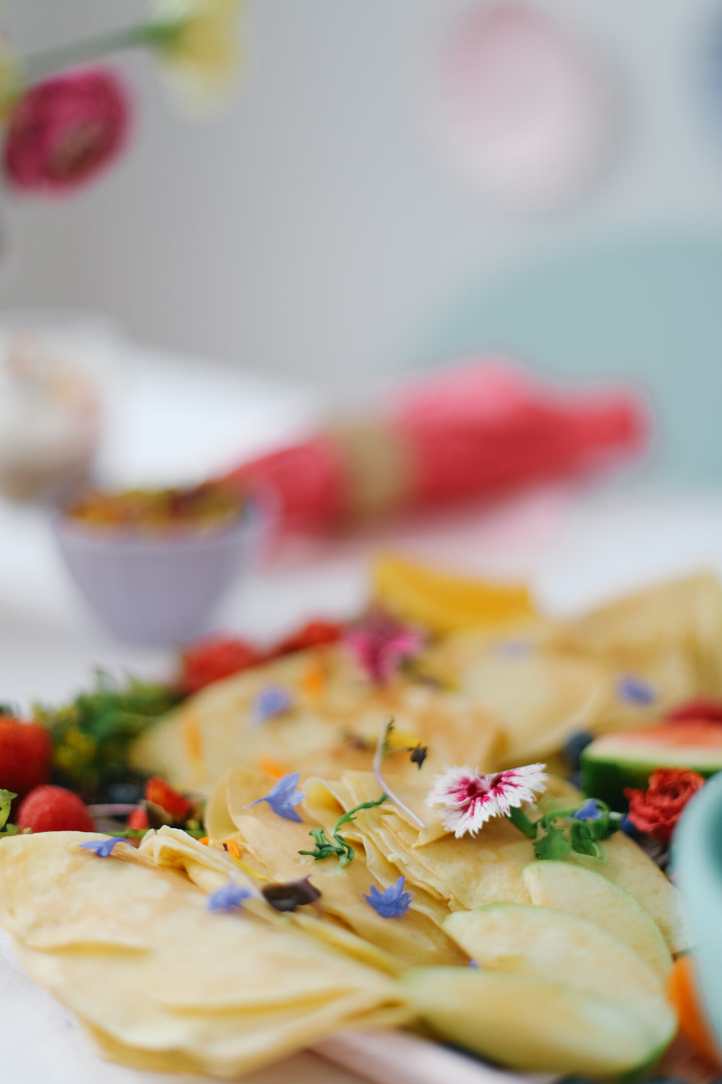 crepes with edible flowers in a table